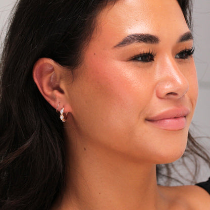 Boucles d'oreilles Huggie en argent sterling plaqué or rose avec triple zircone cubique