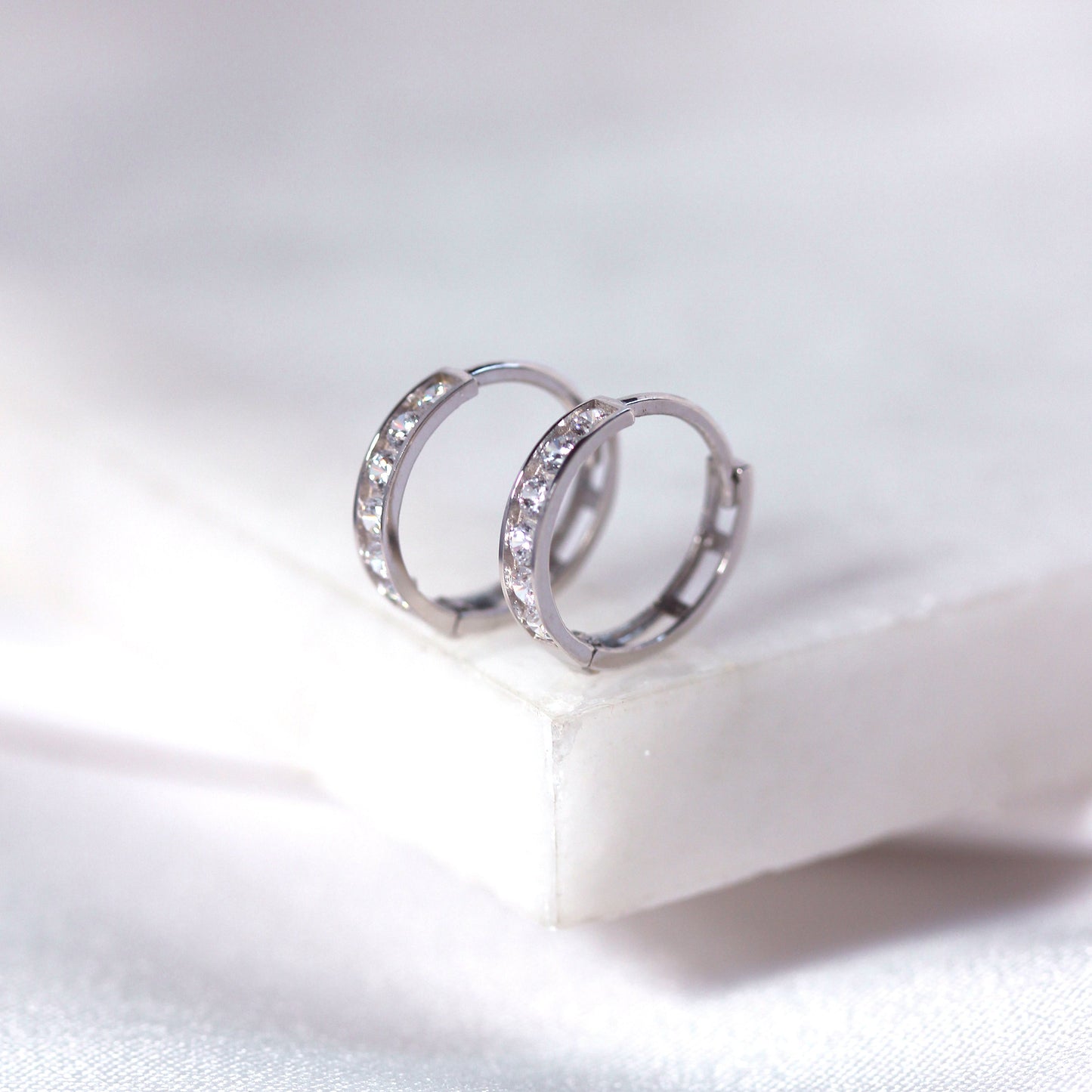 Boucles d'oreilles créoles Huggie en or blanc 9 carats avec zircones cubiques serties en canal de 12 mm