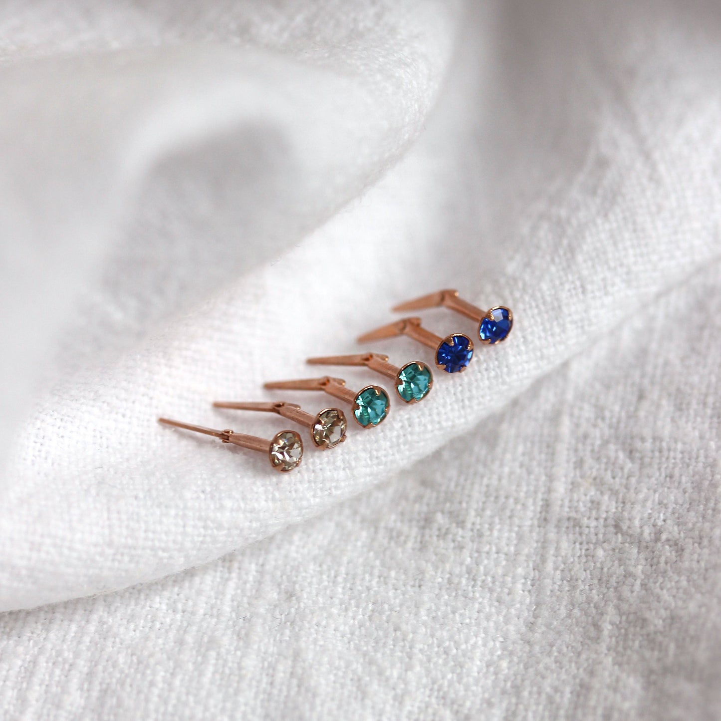 Boucles d'oreilles à tige Andralok en or rose 9 carats avec saphir aigue-marine transparent en oxyde de zirconium de 3 mm